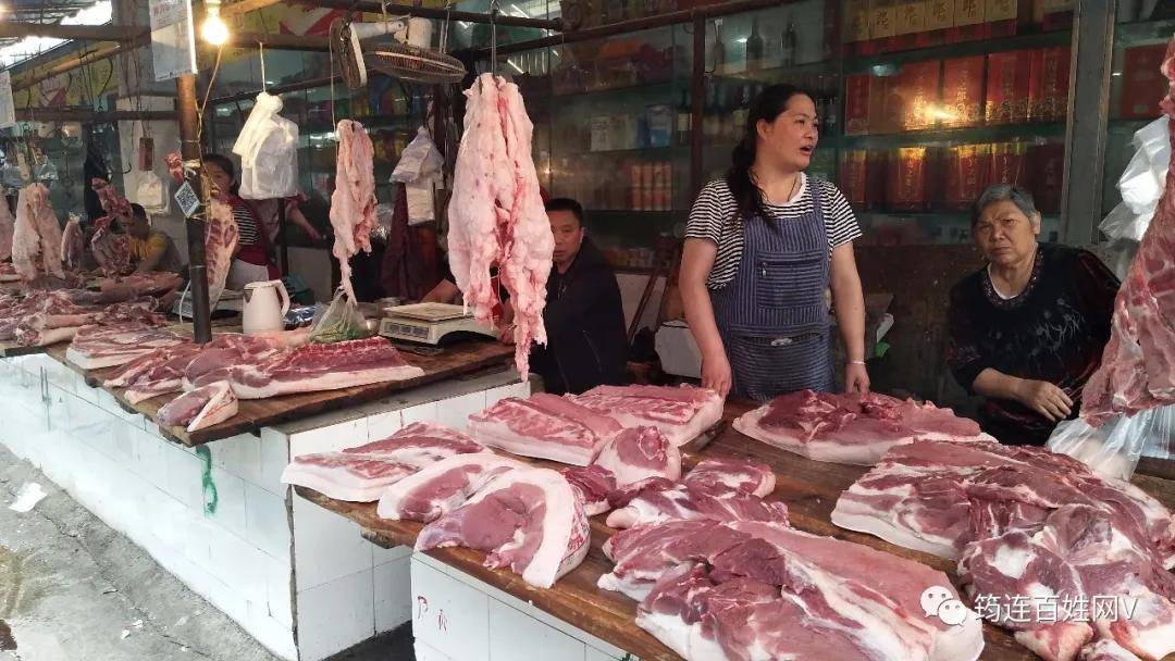 猪肉市场里买肉的人不算多,但是摊位前还是有不少人来来往往的.
