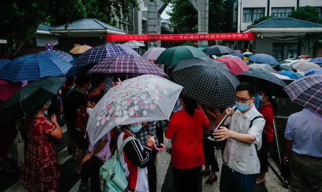武汉家长暴雨中送考画面令人泪目口罩旗袍天团亮相为孩子加油