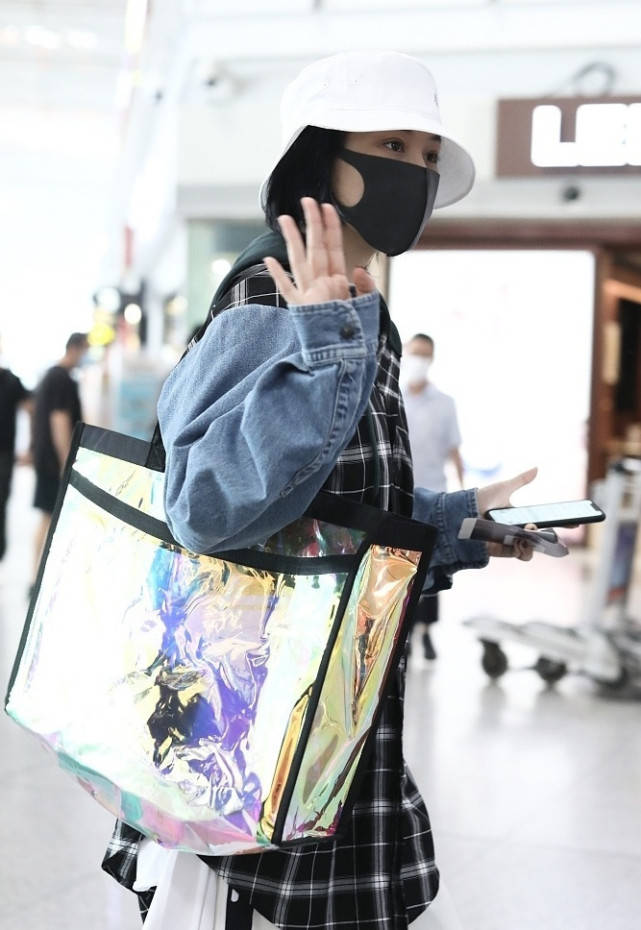 张馨予高调秀恩爱，混搭造型亮相机场，手机壳