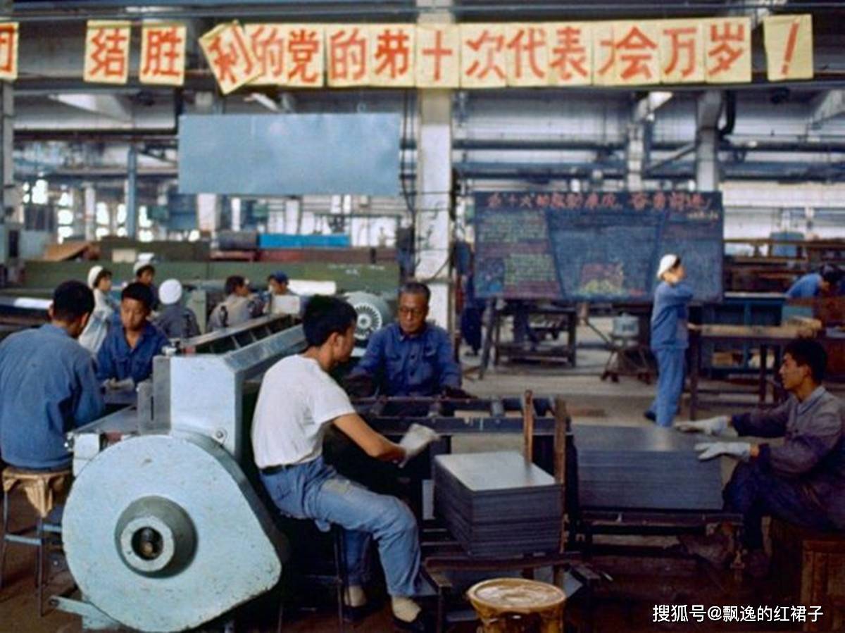 1980年代的大型国营工厂,一个男工人正一边吃饭一边看工厂里发出的