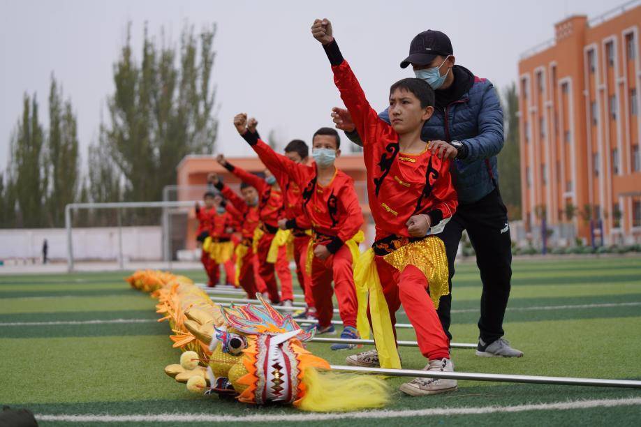 明德小学舞龙队的孩子们在援疆教师邬健勇的指导下认真练习动作, 为