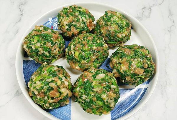 步:取适量的鲜肉荠菜肉末,用左右手,在手掌中,来回紧一紧鲜肉荠菜丸子