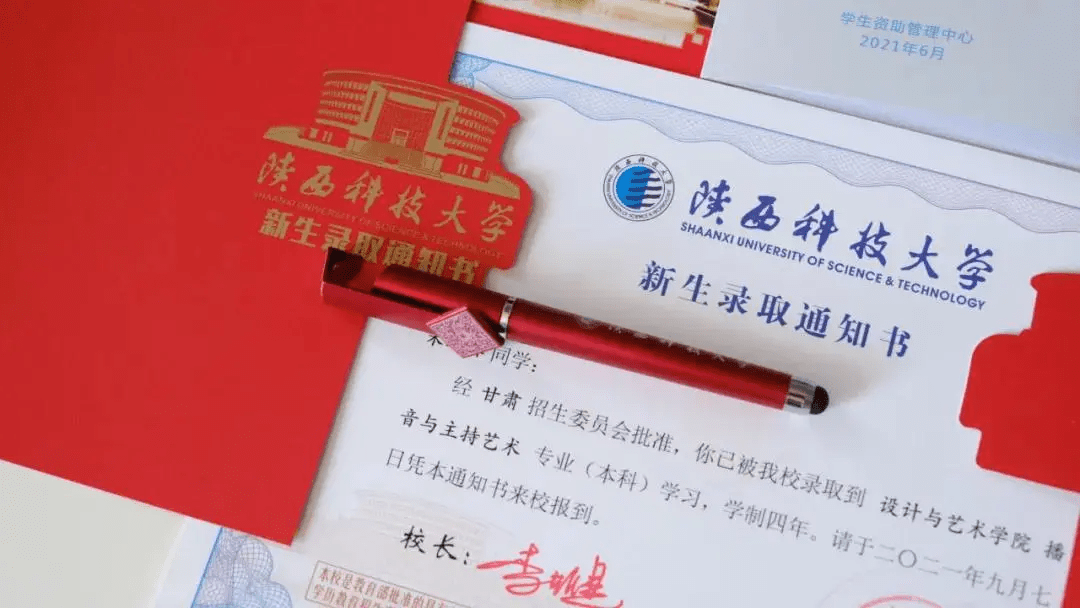 陕西科技大学2021年的录取通知书以学校标志性建筑物图书馆及校徽为