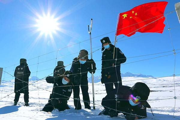 图为衣拉克素边境警务站民警在巡逻时对边境设施进行修缮.