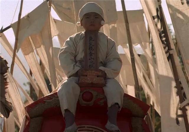 坐在灵柩之上所谓"亲子"年幼的天白面无表情,出殡的众人披麻戴孝机械