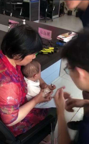 疼！婴儿右手指被卡螺丝帽，家长抱孩子到消防队救助