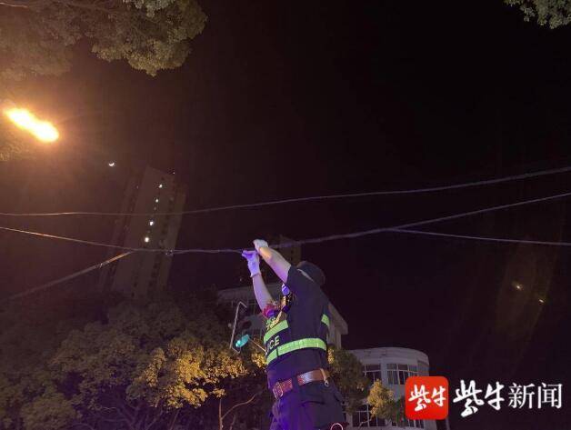报警|电线挂落挡路造成交通拥堵，民警托举电线恢复通畅