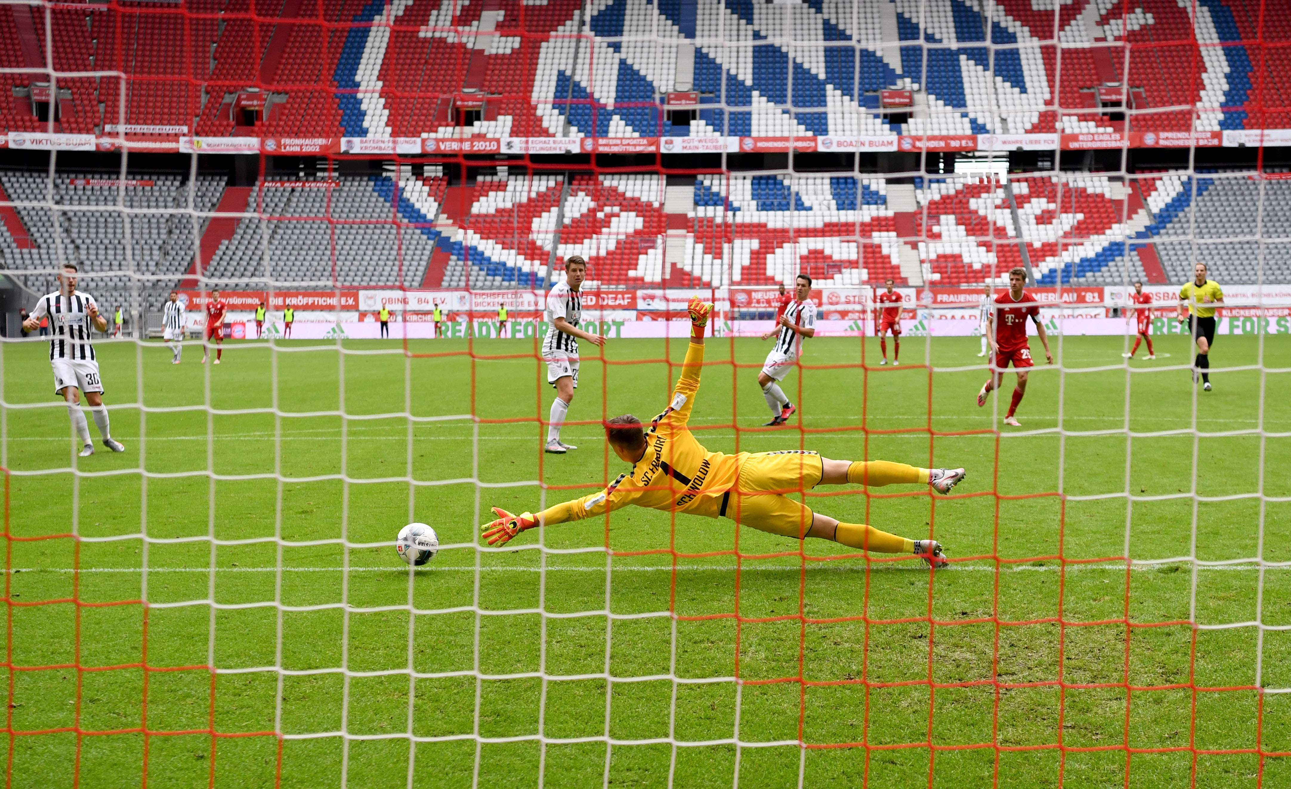 6月20日,弗赖堡队守门员施沃洛(前)在比赛中扑救.
