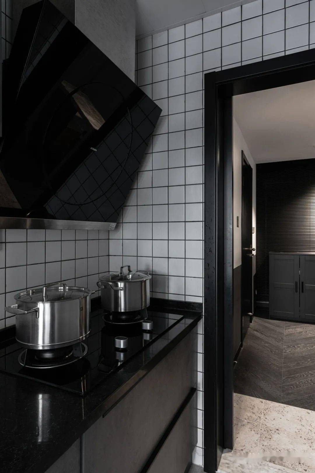 厨房是白色小方砖铺墙,橱柜选用的深灰色,搭配黑色台面