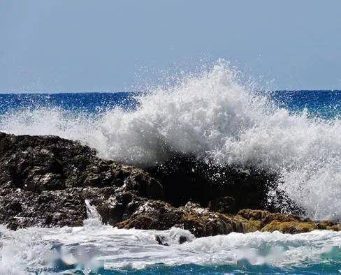 礁石傲然挺立着,向礁石发起冲击,发出震耳欲聋的声音,海浪咆哮着,不然