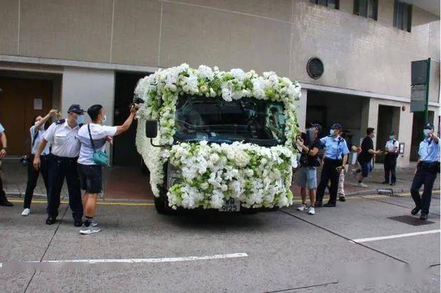除了车头的玻璃,灵车周围铺满了白花,非常高贵.