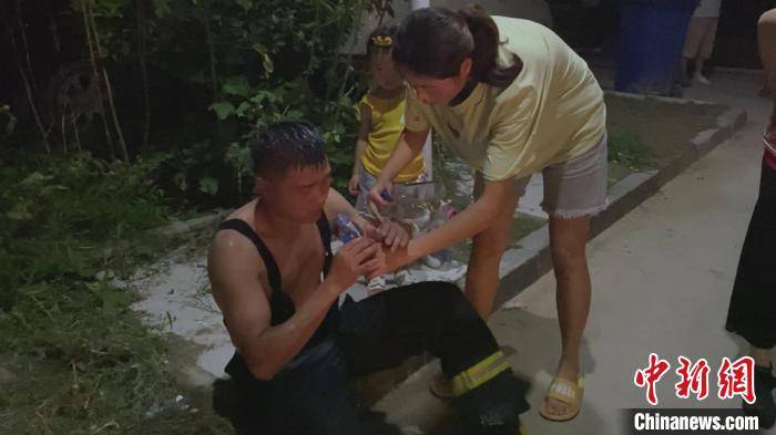 市民|消防员救火热晕倒地 市民为其淋水扇扇子降暑