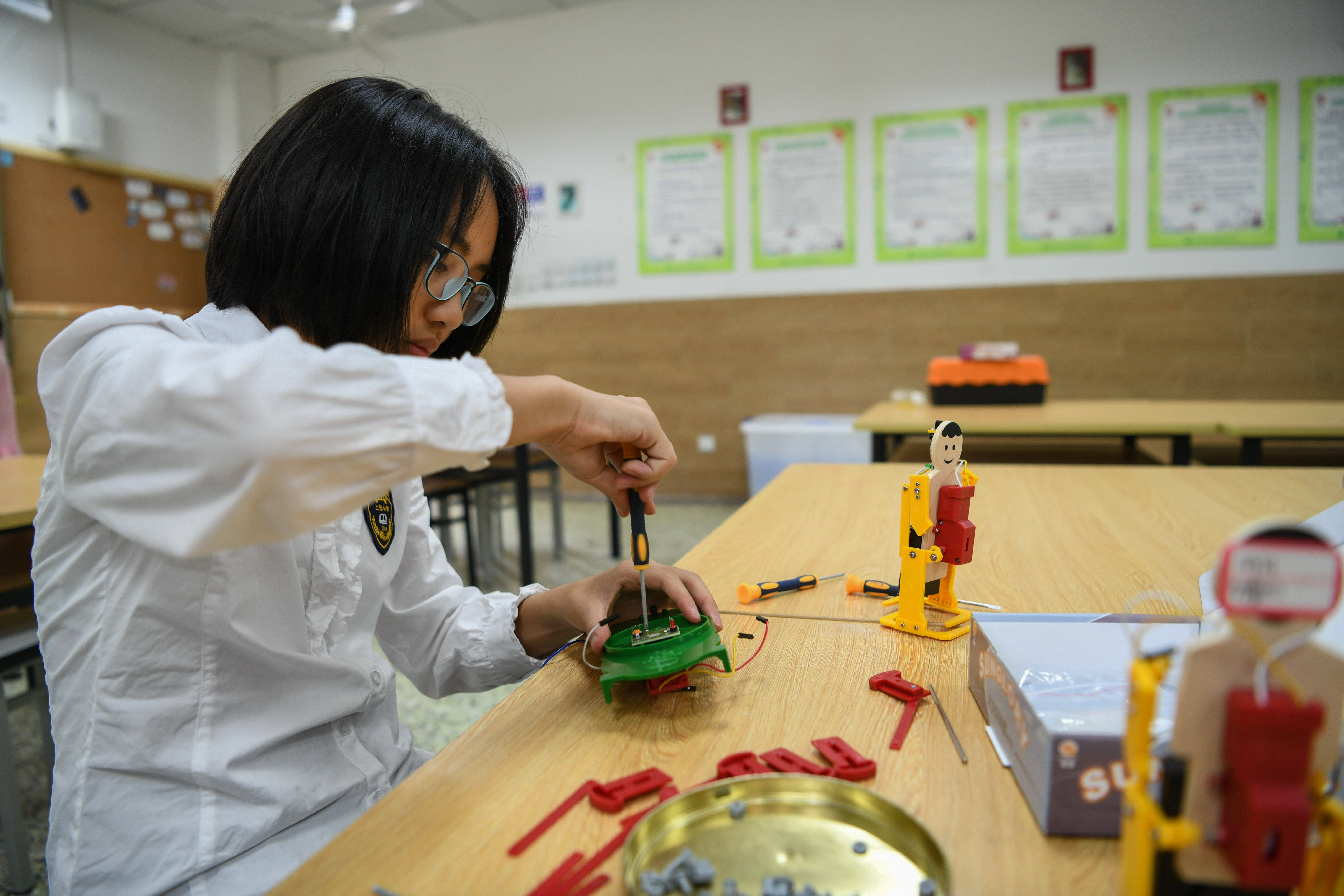 图为在四川师范大学附属上东小学,胡馨知在拼接太空探测器模型(8月6日