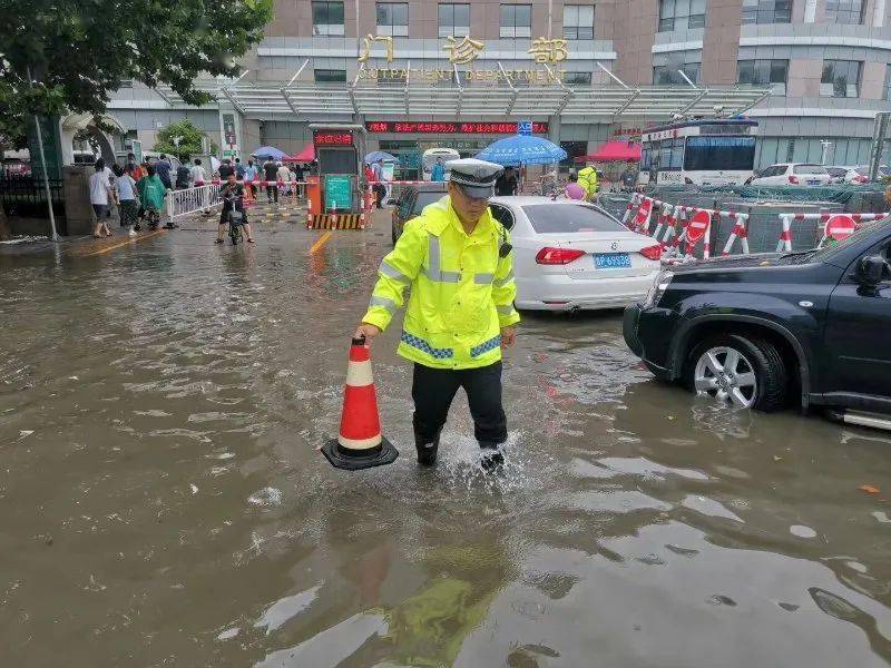 查看积水情况,由于积水能明显没过雨靴,执勤交警根据经验,个个脚穿
