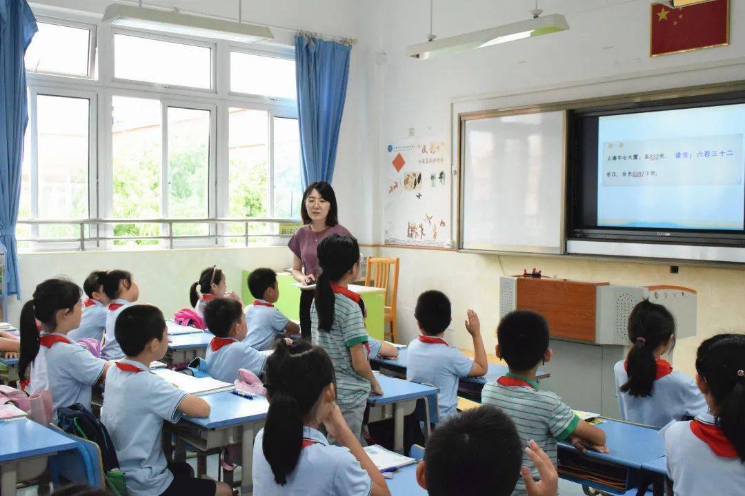 讲台上的老师正在教学生认识"大数,而郑狄芳正一边听,一边记录着.