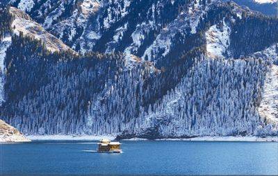 日前,游客乘画舫在天山天池景区欣赏雪景.何龙/摄