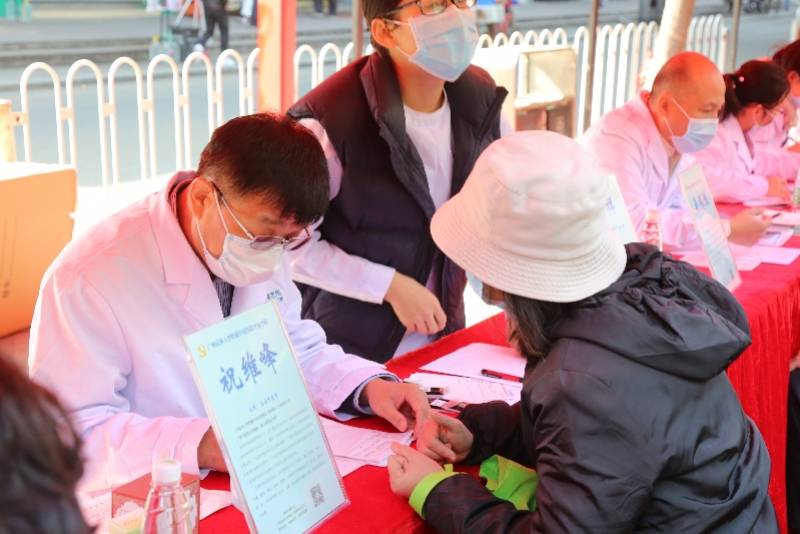 广州医科大学附属中医医院院长祝维峰在为街坊提供义诊服务.