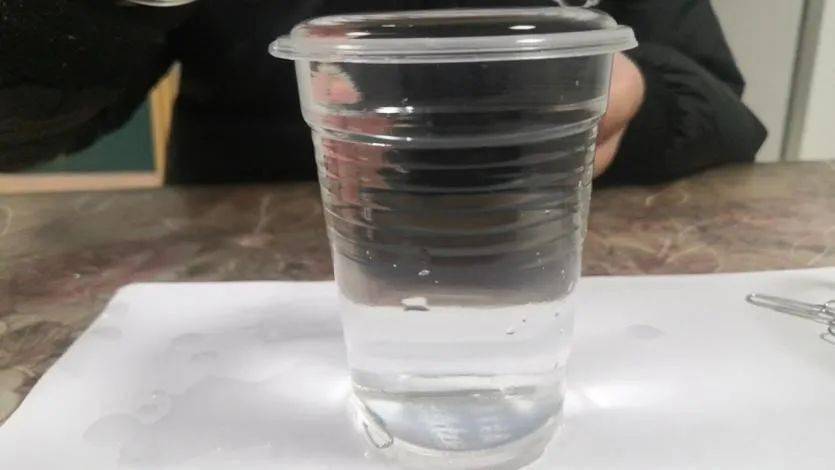 2.往水杯中轻轻放入一个回形针,水没有溢出水杯.1.