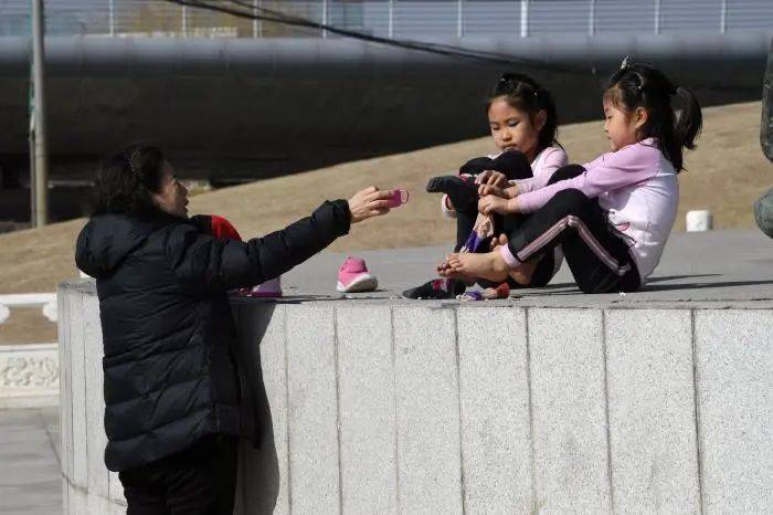脱掉棉鞋和袜子玩耍的小女孩|北青-北京头条记者 黑建军 摄