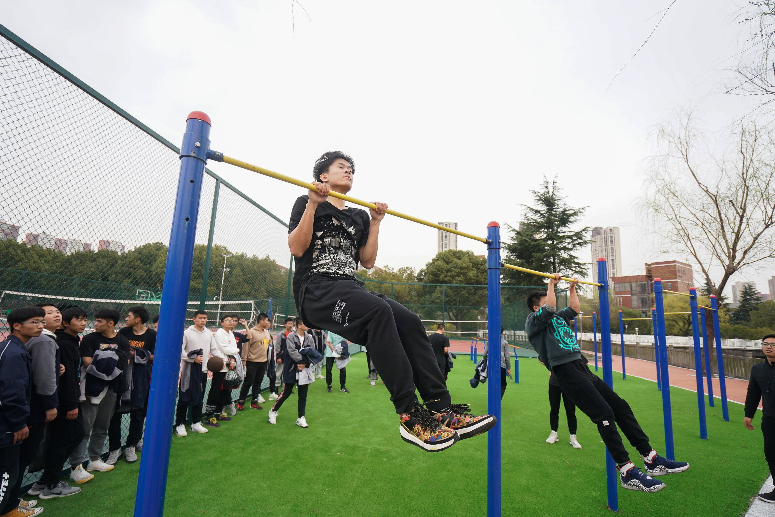 3月10日,在江苏省锡山高级中学,学生在做引体向上.