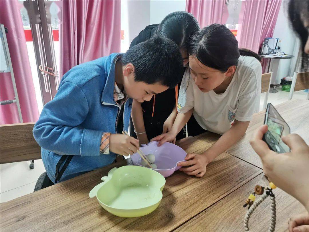 筷子夹兵乓球游戏场面热烈,有的孩子途中乒乓球掉落也没有放弃,捡起就