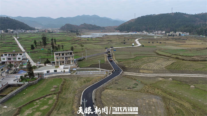 12月17日,工人在龙里县湾滩河镇翠微村杉木寨道路建设施工中摊铺沥青