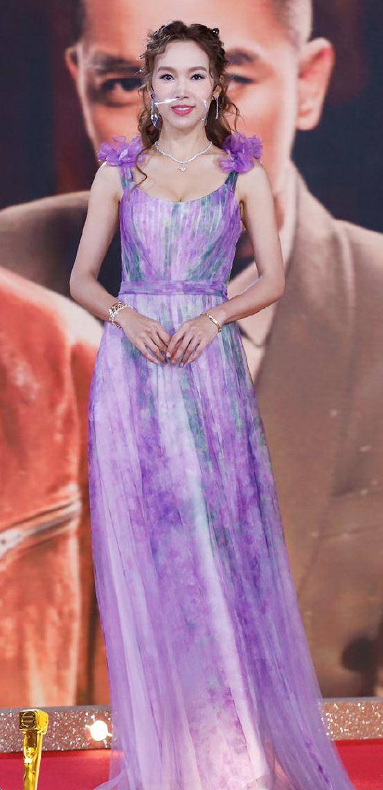 傅嘉莉穿了一条紫色裙子,看起来不太高级,尤其肩膀还有两朵紫色的花