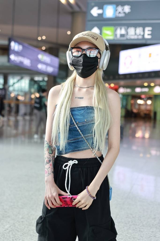 乃万现身上海机场头戴耳机身穿露脐装青春靓丽