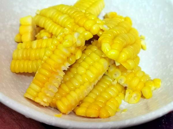 玉米蒸熟,直接成段,再片下一整片的玉米片,码在成品盘,上面放烤鳗,撒