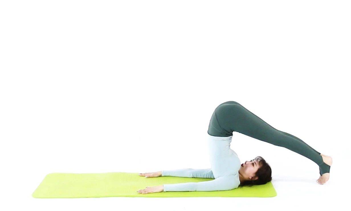 双手,有控制的将胸椎腰椎臀部双腿保持伸直回落到地板上还原仰卧山式