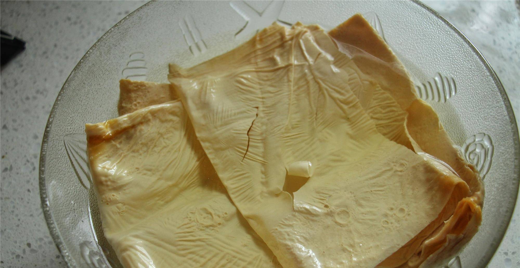 3,腐皮切成小块,宽度为金针菇的三分之二,小葱里面比较长的叶子剪下来