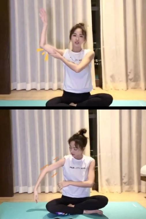 吴谨言减肥运动2:3d天鹅臂坐在瑜伽垫后,双腿伸直,双手交叉朝脚底勾