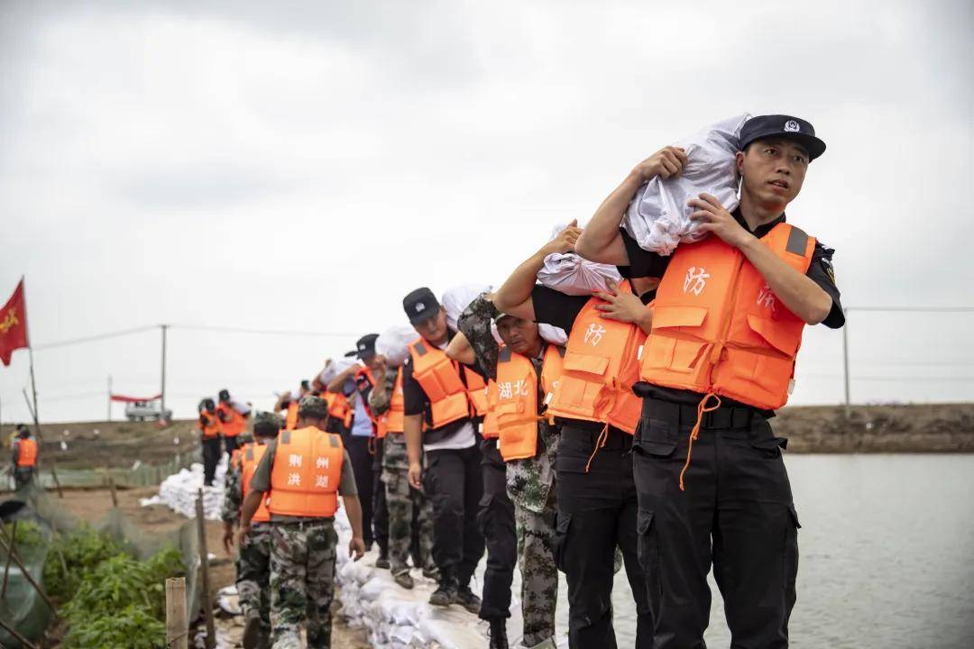 7月15日,洪湖市公安局民警在洪狮围堤紧急加固子堤
