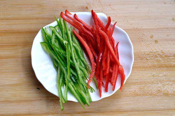 青红椒切去蒂,把辣椒籽去除切成细丝备用.