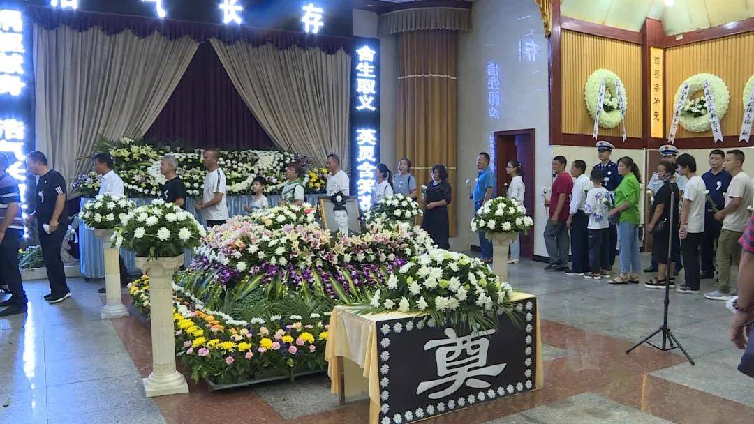 双手接过烈士的遗像和骨灰盒,缓步将其送进开阳县殡仪馆