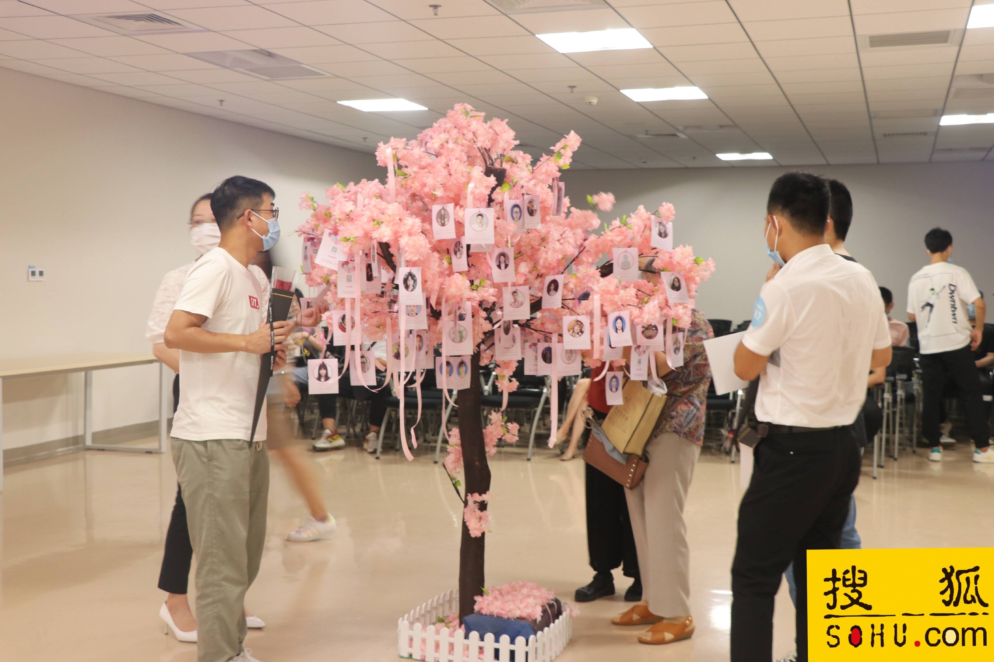 1/ 12 活动开始之前,有许多男女嘉宾到场签到并领取象征爱情的玫瑰花.