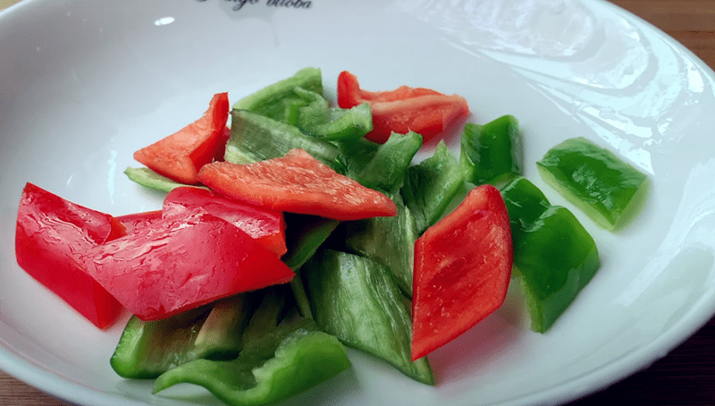 2.青红甜椒,切菱形片放入碗中备用.