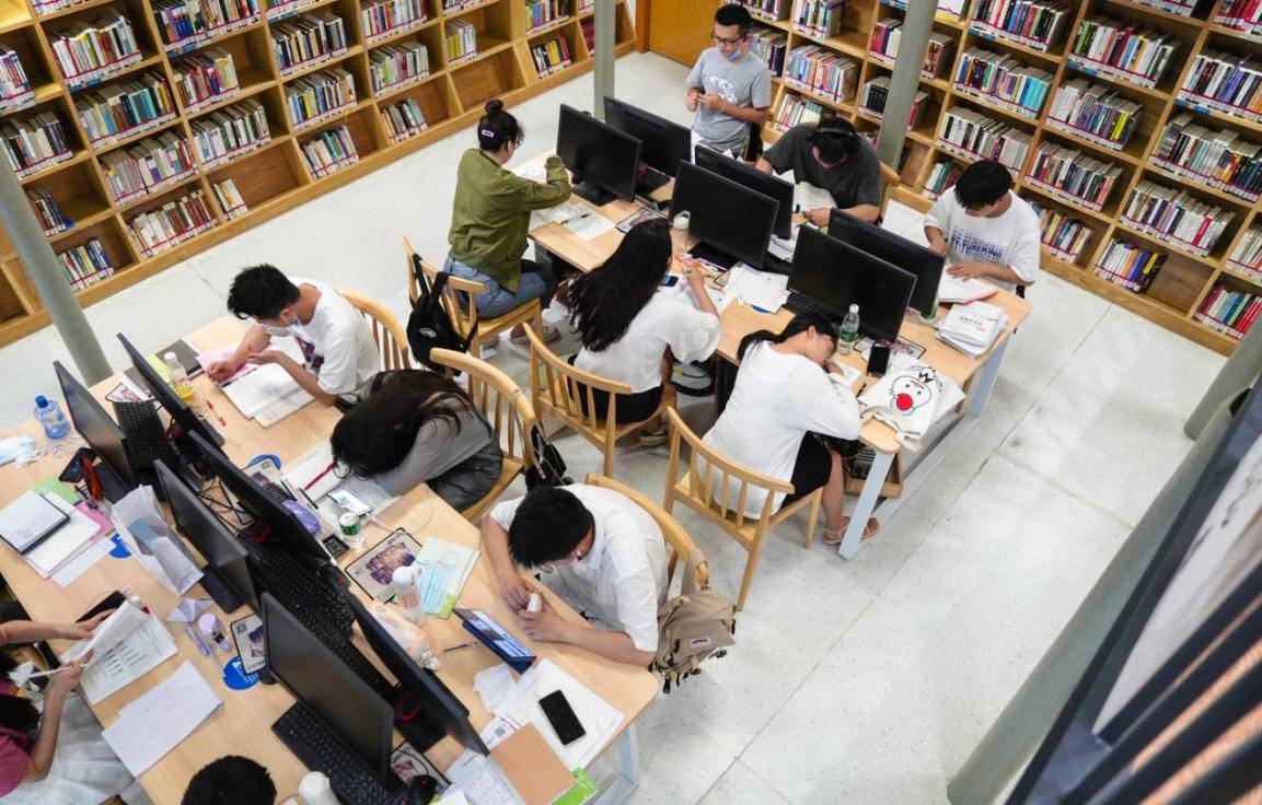 圖書館裡,各個區域坐滿了埋頭摘抄筆記的學生,查找資料的市民,雙手