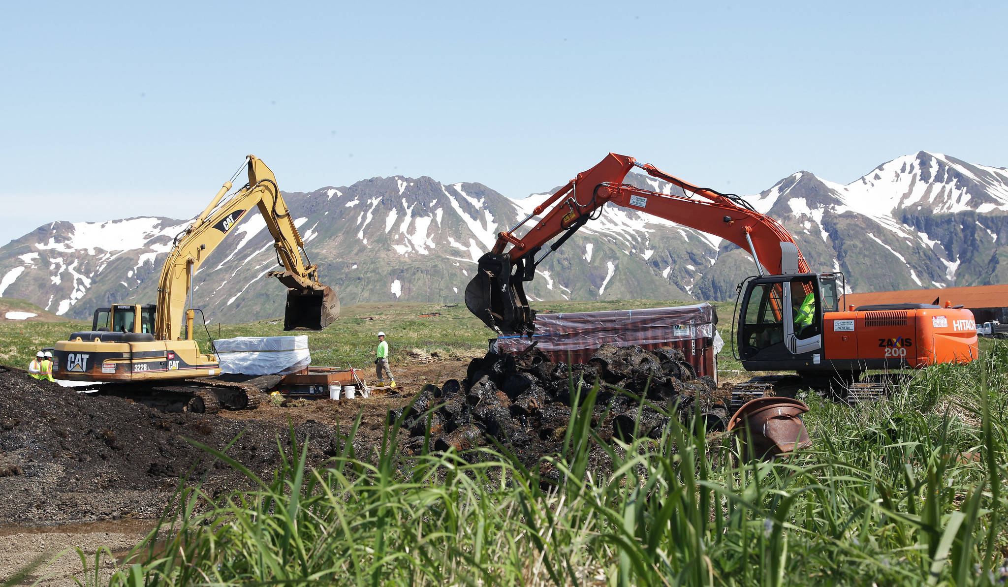 2台挖掘机把储存泄露的石油挖出来