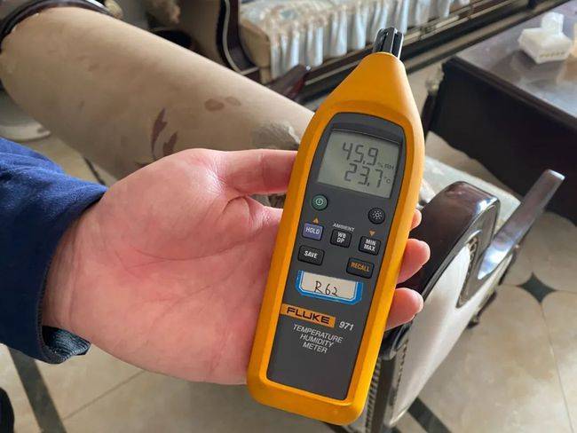 郑州热力公司工作人员到用户家中测试室内供暖温度