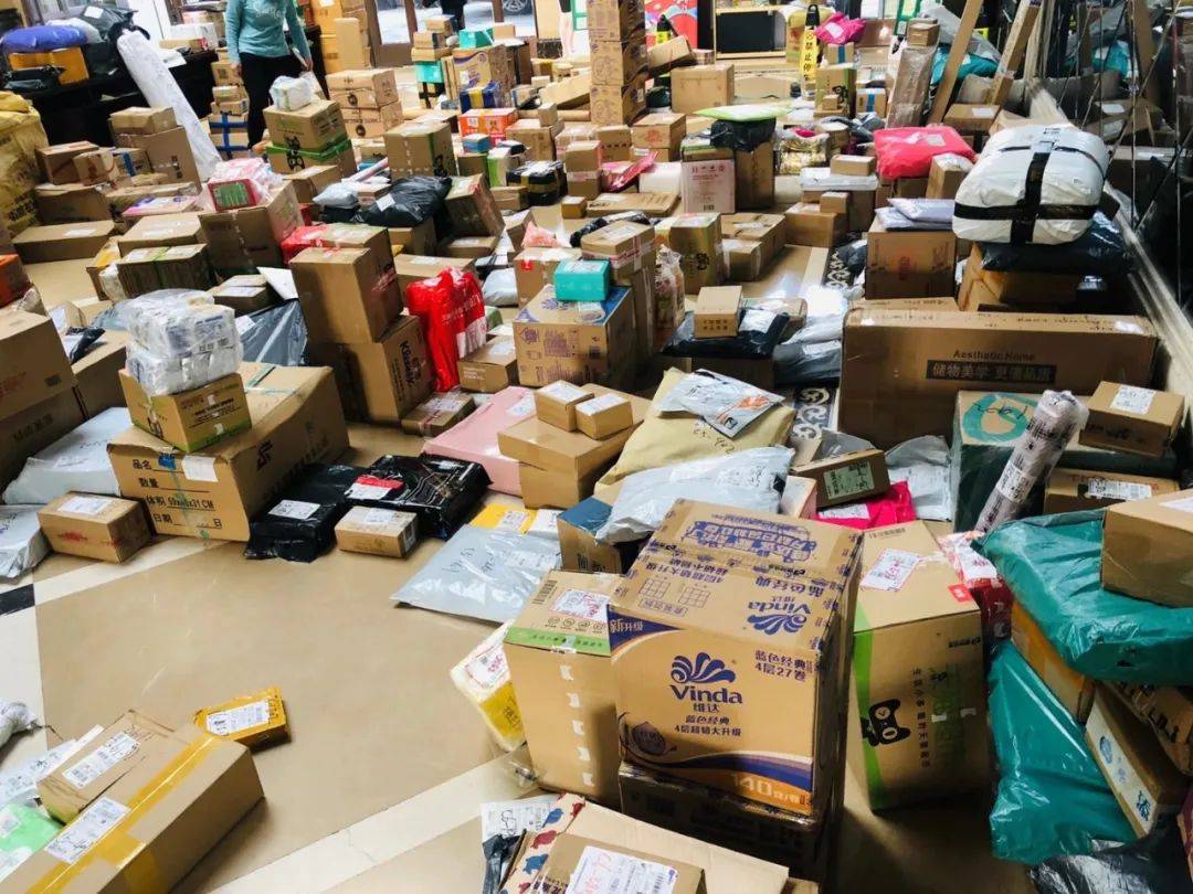 有业主正在成堆的快递中寻找自己的那一个小区的会所内快递堆积如山从