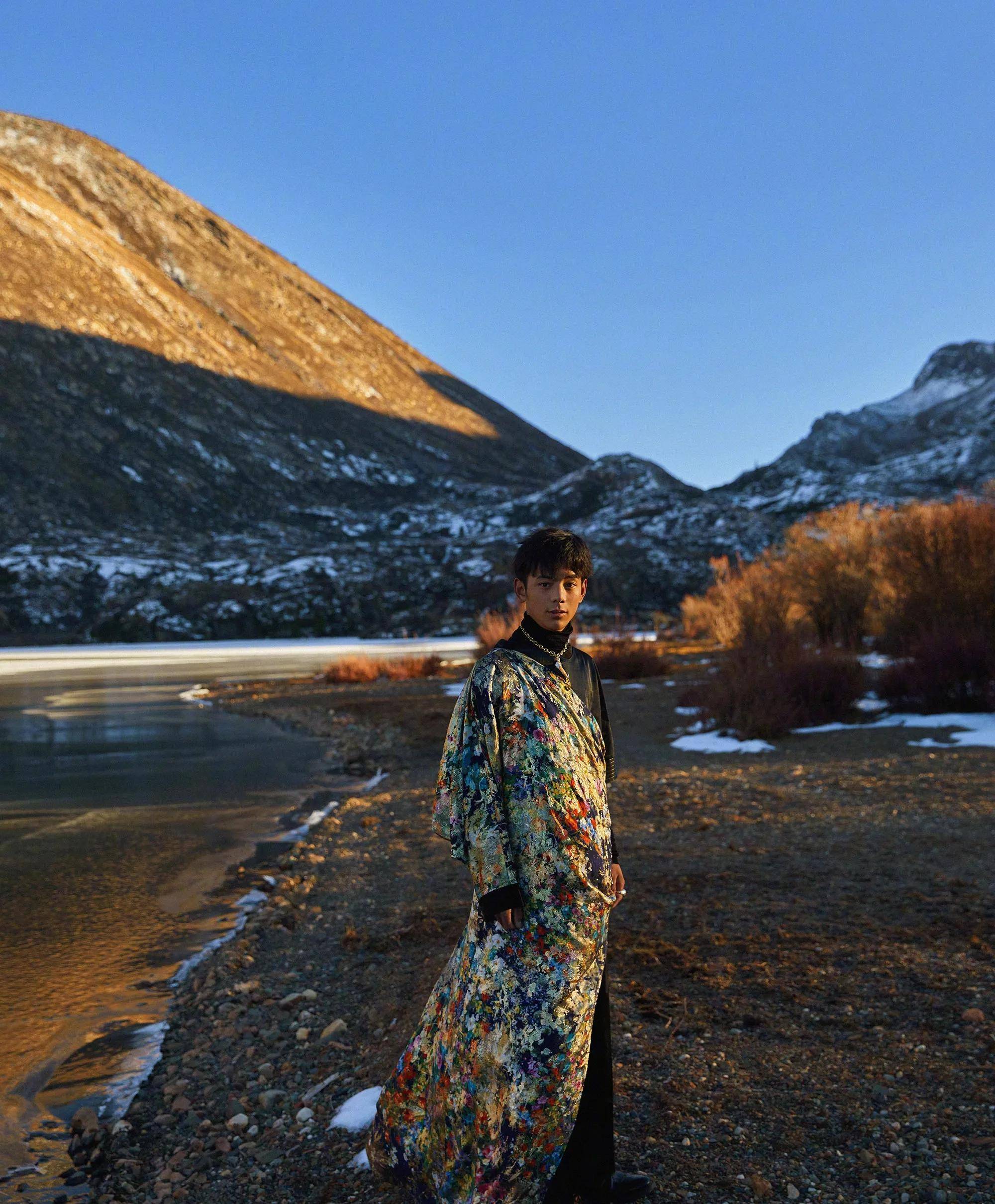 雪山下,溪水潺潺从脚边流过,岸边的丁真,被阳光笼
