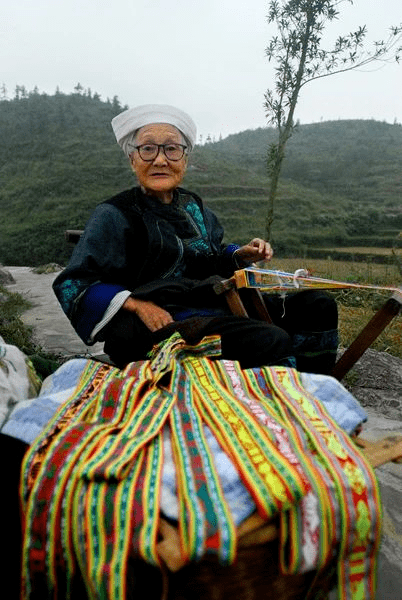 州县结合非遗保护发展乡村旅游,推进扶贫攻坚,苗族老人边打花带,边