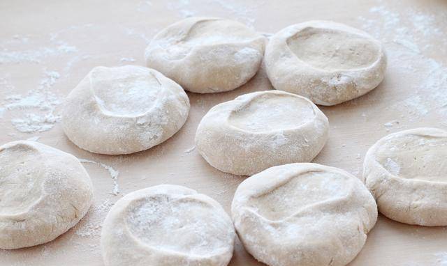 然后用擀面杖将面剂子擀成稍微厚一些的饼皮,不操作的面团记得要覆盖