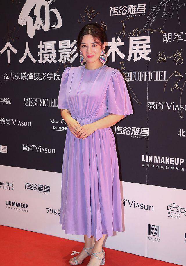 出席活动时,黄奕身穿一件紫色的连衣裙亮相,温婉优雅,端庄得体,微微