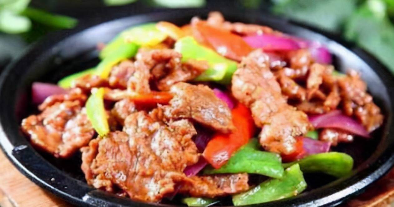 铁板牛肉4.倒入青椒丝,翻炒,再放入少许盐炒匀,起锅装盘即可.3.