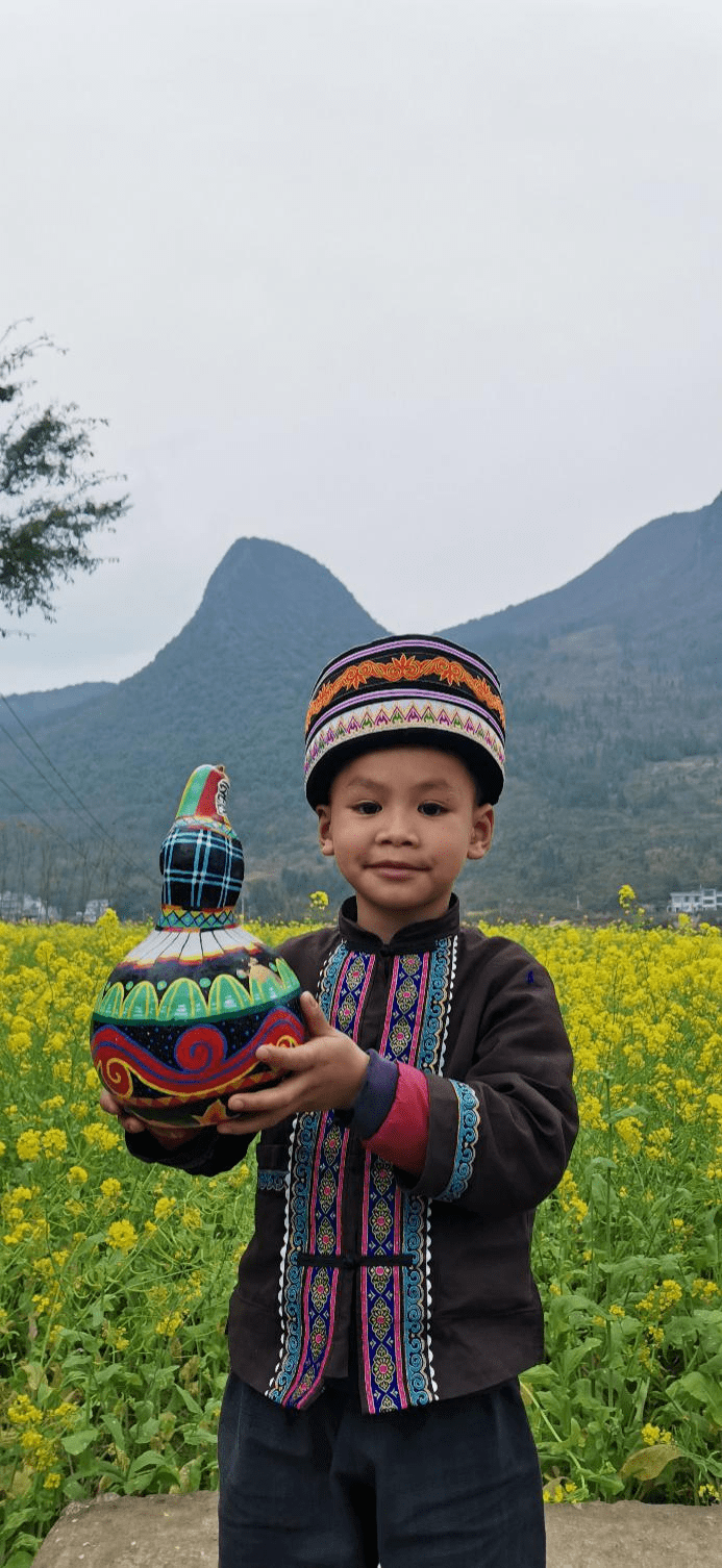 图三:布依族小男孩手捧葫芦小男孩手中的葫芦图案以布依族特色服饰为