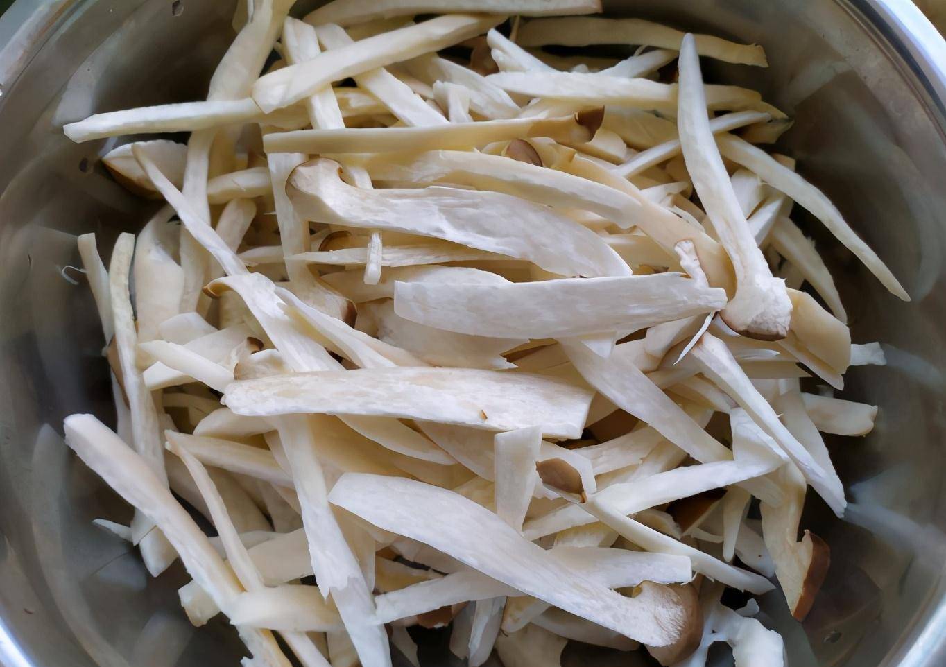 3,杏鲍菇处理好了后,用刀把青辣椒和干辣椒切成段,姜切丝,大蒜剥皮