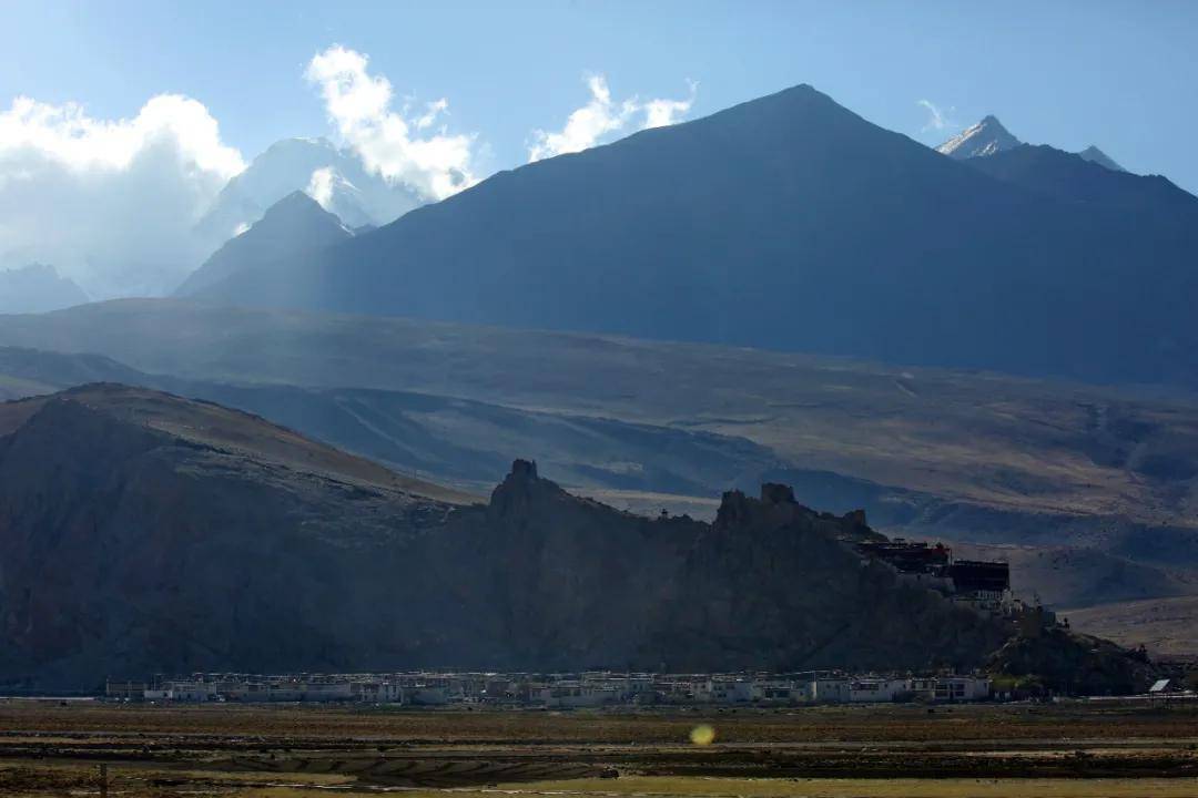 萨尔乡拉康村大山脚下的藏族村寨定结县附近的叶如藏布湿地牧场远方一