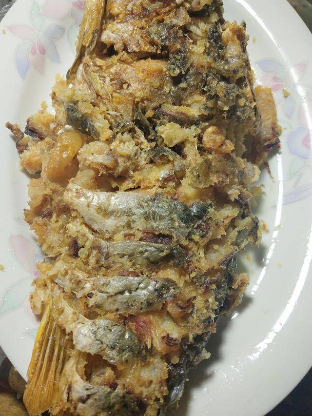 4放入鲤鱼,中火炸制鲤鱼两面焦黄,捞出控油,放入鱼盘中.